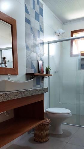 a bathroom with a toilet and a sink and a shower at Refúgio Arraial - Casa em Arraial d'ajuda in Arraial d'Ajuda