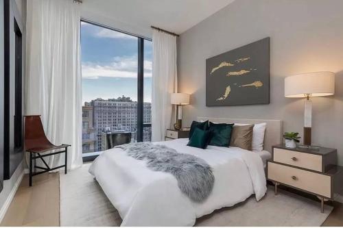 a bedroom with a large bed and a large window at Lovely 3 Bedroom Condo near Central Park in New York