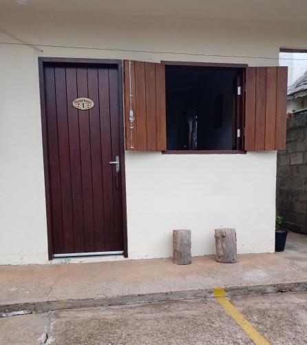 a house with a wooden door and two windows at Apartamentos Roncalli Monte Verde in Monte Verde