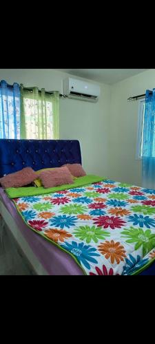 a bed with a colorful blanket on top of it at Residencial caonabo tower in SJM