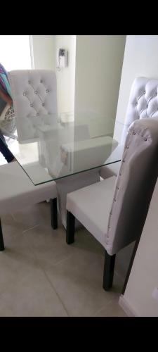 une table en verre avec une chaise et un banc en verre dans l'établissement Residencial caonabo tower, à SJM