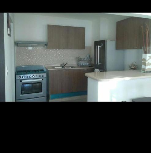 a kitchen with a stove and a refrigerator at Residencial caonabo tower in SJM
