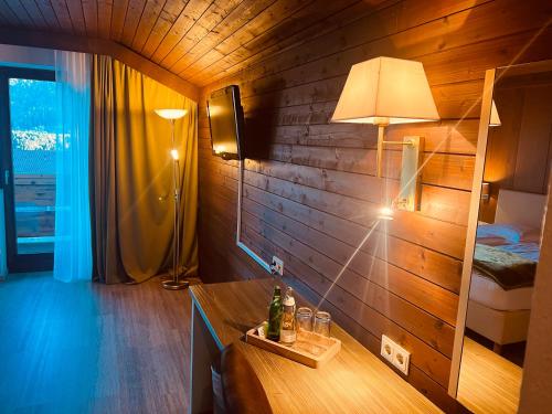 a room with a table with a lamp and a bedroom at Hotel Montana in Telfes im Stubai
