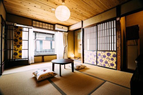 een kamer met een tafel en twee kussens op de vloer bij Tsukito in Kyoto