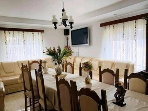 - une salle à manger avec une table, des chaises et une télévision dans l'établissement La Capra Vecinului, à Oglinzi
