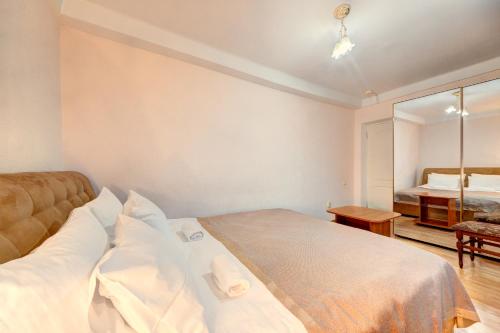 a bedroom with a large bed and a mirror at Holosiyvsky Hotel in Kyiv