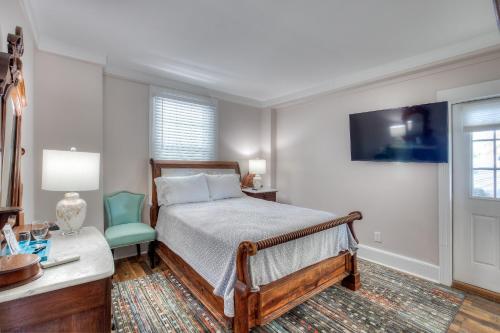 a bedroom with a bed and a desk with a chair at Elaine's Cape May Boutique Hotel in Cape May