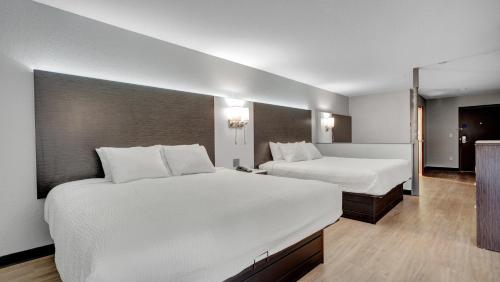 a hotel room with two beds and a television at Days Inn & Suites by Wyndham Niagara Falls/Buffalo in Niagara Falls