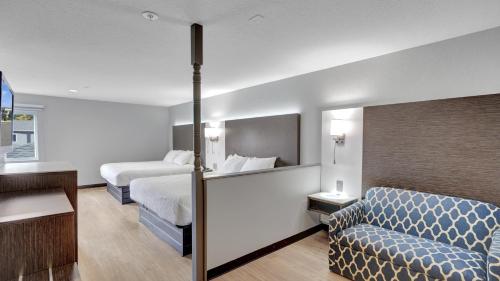 a hotel room with a bed and a couch at Days Inn & Suites by Wyndham Niagara Falls/Buffalo in Niagara Falls
