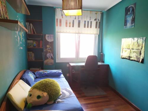 TUS VACACIONES EN SANTANDER في سانتاندير: غرفة نوم للأطفال مع دمية ملقاة على سرير