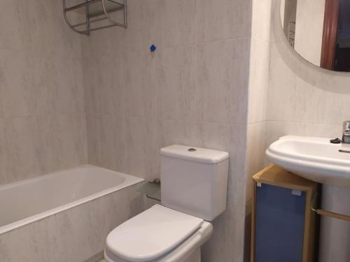 Baño blanco con aseo y lavamanos en TUS VACACIONES EN SANTANDER, en Santander
