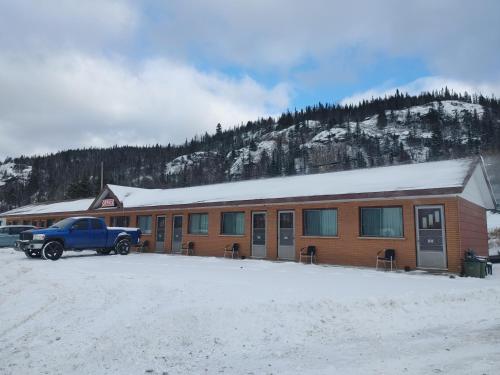 un camion garé devant un bâtiment dans la neige dans l'établissement Sunset Motel, à Schreiber
