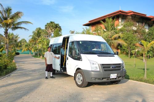 a man and a woman standing next to a white van at Angkor Palace Resort & Spa in Siem Reap