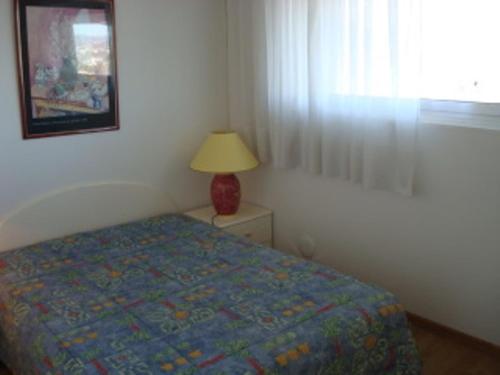 une chambre avec un lit, une lampe et une fenêtre dans l'établissement Location Appart Climatisé - 4 Couchages - Villeneuve-Loubet Plage - FR-1-252A-32, à Villeneuve-Loubet
