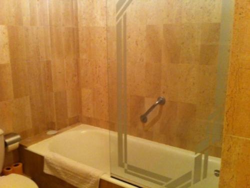 une salle de bain avec une baignoire et une porte de douche en verre dans l'établissement Location Appart Climatisé - 4 Couchages - Villeneuve-Loubet Plage - FR-1-252A-32, à Villeneuve-Loubet