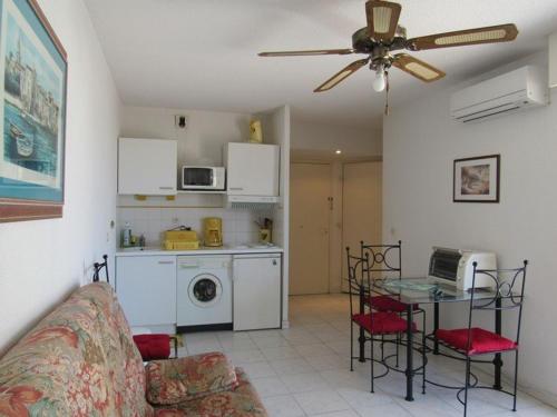 un salon avec un canapé et une table et une cuisine dans l'établissement Appartement calme au cœur de Cavalaire, climatisé avec terrasse, parking et toutes commodités - FR-1-100-233, à Cavalaire-sur-Mer