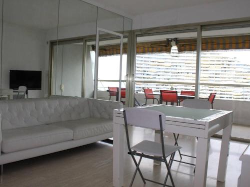 un salon avec un canapé, une table et des chaises dans l'établissement Villeneuve-Loubet : Appartement avec Terrasse, Climatisation et Garage - FR-1-252A-34, à Villeneuve-Loubet