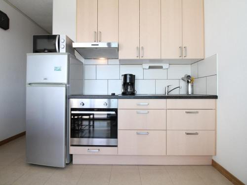 Il comprend une cuisine équipée d'un réfrigérateur et d'une cuisinière. four supérieur dans l'établissement T1 à Balaruc-les-Bains avec Clim et Wifi - FR-1-553-39, à Balaruc-les-Bains