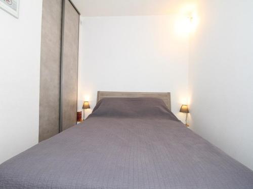 Ce lit se trouve dans un dortoir blanc doté de 2 lampes. dans l'établissement T1 à Balaruc-les-Bains avec Clim et Wifi - FR-1-553-39, à Balaruc-les-Bains