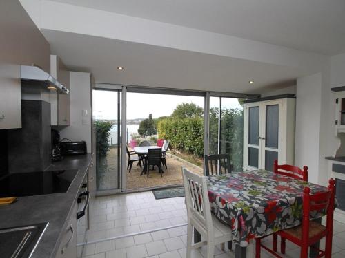 une cuisine avec une table et une vue sur un patio dans l'établissement T2 rénové avec jardin et parking, proche Thermes, clim, wifi, lave-linge - FR-1-553-54, à Balaruc-les-Bains