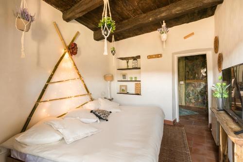 um quarto com uma cama branca num quarto em Opera Suites - Il sentiero della felicità em Calcata