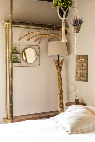 a bedroom with a bed and a mirror and a lamp at Opera Suites - Il sentiero della felicità in Calcata