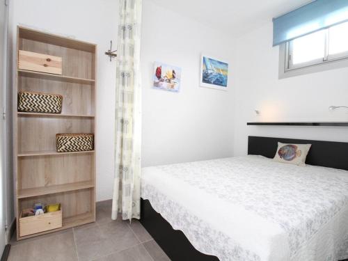 une chambre avec un lit et une étagère dans l'établissement T1 Rénové près des Thermes, Parking Privé, Balaruc-les-Bains - FR-1-553-125, à Balaruc-les-Bains