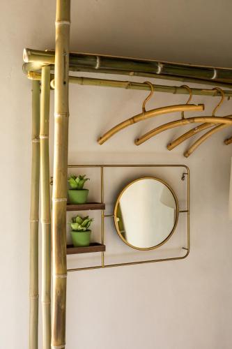 a mirror on a wall with bamboo poles at Opera Suites - Il sentiero della felicità in Calcata