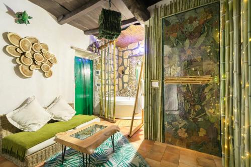 a room with a green bed and a wall with a mural at Opera Suites - Il sentiero della felicità in Calcata