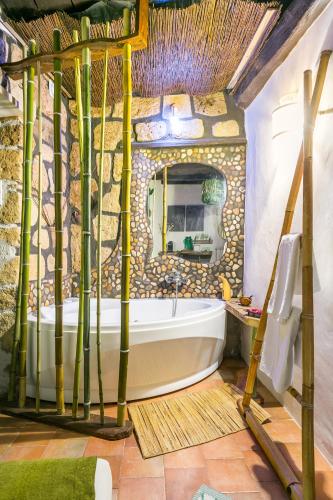 a bathroom with a tub in a stone wall at Opera Suites - Il sentiero della felicità in Calcata