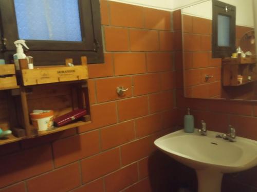 an orange tiled bathroom with a sink and a mirror at Monte da Samarra - Alojamento Local in Avis