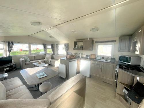 Newton的住宿－Trecco Bay Porthcawl Caravan 8 berth PALMS 4，厨房以及带沙发和桌子的客厅。