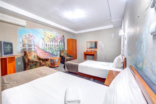 a hotel room with two beds and a painting on the wall at Holosiyvsky Hotel in Kyiv