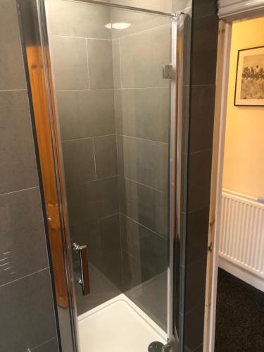 a shower with a glass door in a bathroom at Paula’s place 2 in Balby