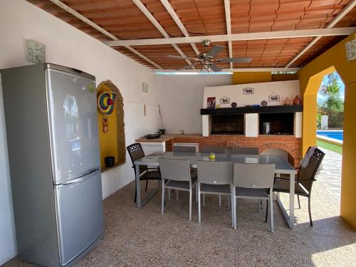 a kitchen and dining room with a table and a refrigerator at Villa Arizona in Catral