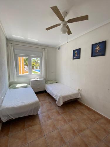 a bedroom with two beds and a ceiling fan at Villa Arizona in Catral