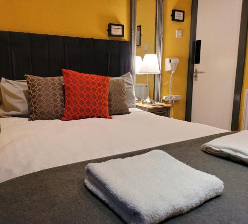 a bedroom with a large bed with red and orange pillows at The Residence - NO 8 in Edinburgh