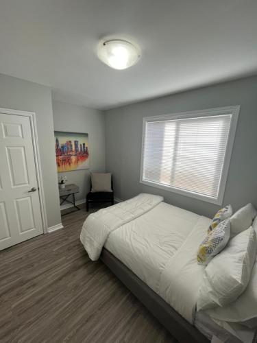 a bedroom with a white bed and a window at Casa LACK - Tranquila Suites 2 in Ottawa