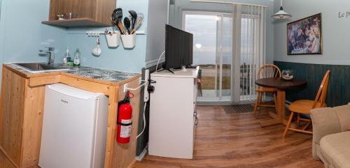 a kitchen with a refrigerator and a counter top at Les Cabines du Phare in Rimouski