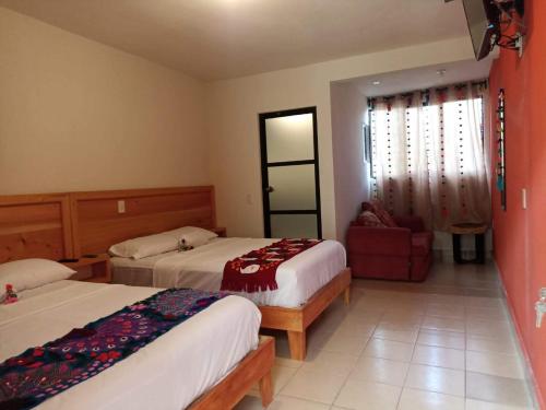 ein Hotelzimmer mit 2 Betten und einem Stuhl in der Unterkunft Suite Villa Real in San Cristóbal de las Casas