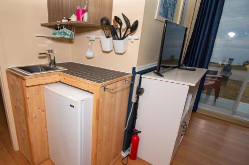 a small kitchen with a refrigerator and a sink at Les Cabines du Phare in Rimouski
