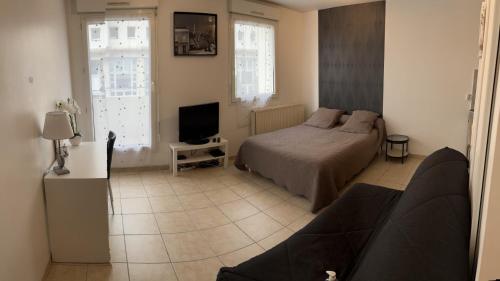 1 dormitorio con 1 cama y TV. en Studio Meublé en Bussy-Saint-Georges