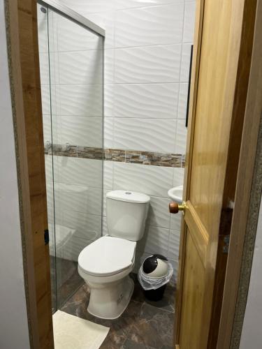 a bathroom with a toilet and a glass shower at Casa Grande in Medellín