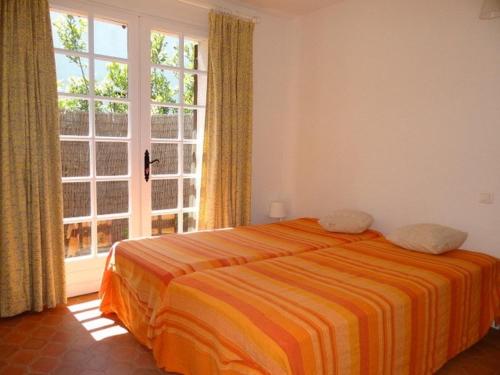 een slaapkamer met een bed en een groot raam bij Villa Cavalaire-sur-Mer, 3 pièces, 6 personnes - FR-1-100-199 in Cavalaire-sur-Mer