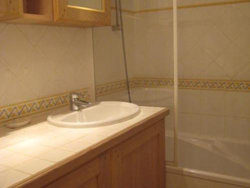 une salle de bain avec un lavabo et une baignoire dans l'établissement Appartement T3 avec grand jardin privé, climatisation et parking - FR-1-100-205, à Cavalaire-sur-Mer
