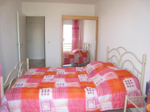 - une chambre avec un lit et une couverture colorée dans l'établissement Charmant T2 cabine 40m², centre-ville, balcon, clim, ascenseur, à Cavalaire-sur-Mer - FR-1-100-224, à Cavalaire-sur-Mer