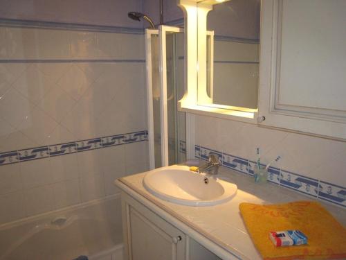 une salle de bain avec un lavabo, un miroir et une baignoire dans l'établissement Superbe appartement T3 avec terrasse et parking à Cavalaire-sur-Mer - FR-1-100-206, à Cavalaire-sur-Mer