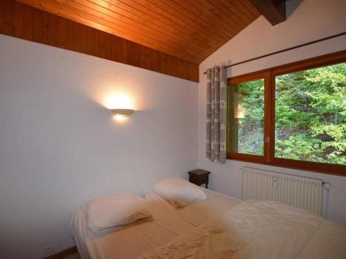 a bedroom with a bed and a window at Appartement Le Grand-Bornand, 4 pièces, 7 personnes - FR-1-241-218 in Le Grand-Bornand