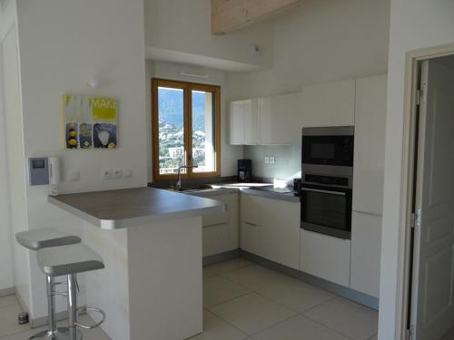 une cuisine blanche avec un évier et une cuisinière four supérieur dans l'établissement Superbe Penthouse T3 Climatisé avec Garage à Cavalaire-sur-Mer - FR-1-100-226, à Cavalaire-sur-Mer