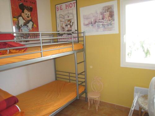 Zimmer mit Etagenbett, 2 Etagenbetten und einem Fenster in der Unterkunft Appartement Cavalaire-sur-Mer, 3 pièces, 6 personnes - FR-1-100-212 in Cavalaire-sur-Mer